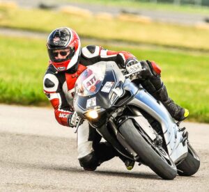 image link to chris's pages. Image of chris on his ducati 848 with his knee down on circuit